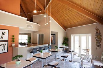 a dining room with tables and chairs and a kitchen